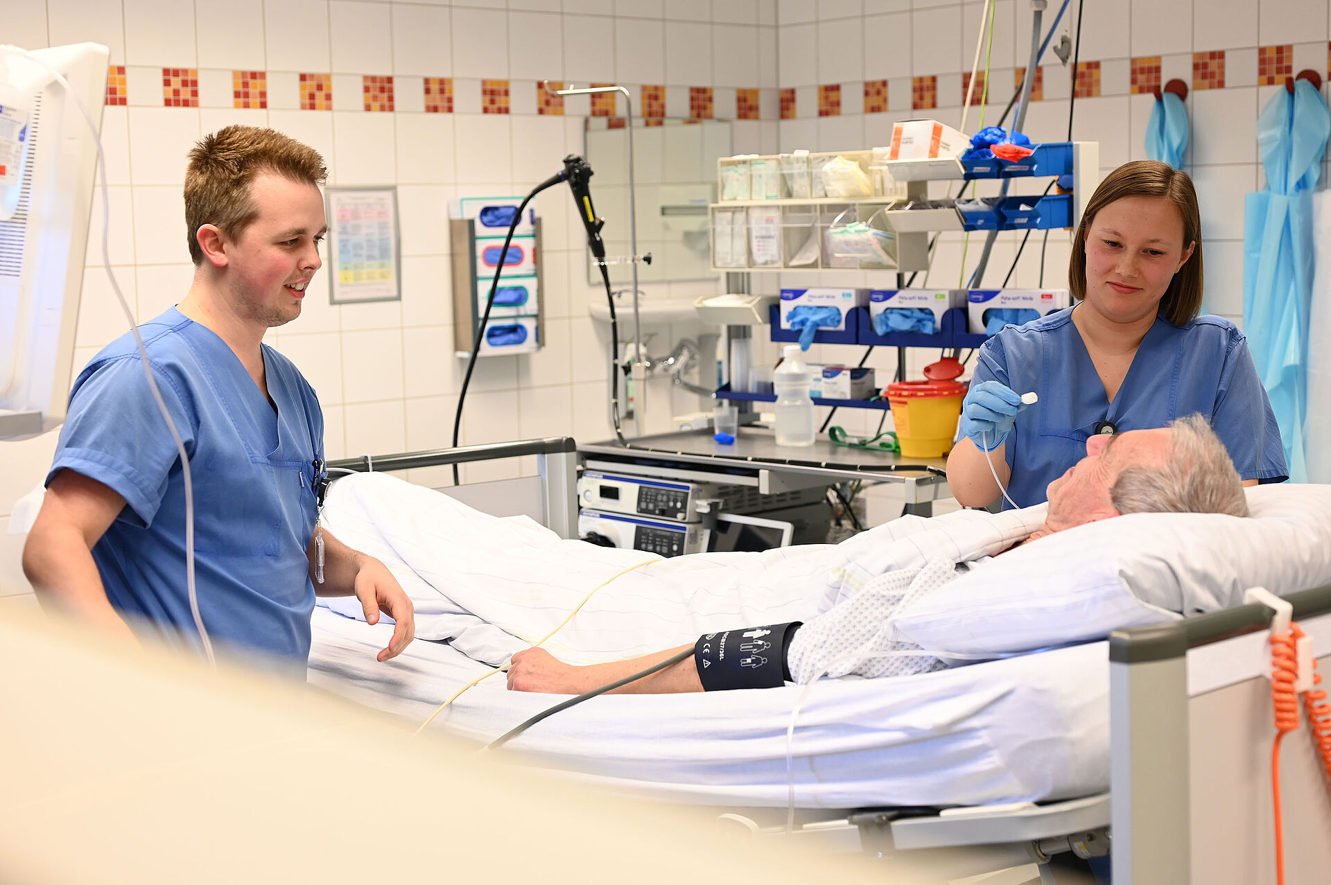 Endoskopie Zwei Pflegekräfte bereiten einen Patienten für eine endoskopische Untersuchung vor.