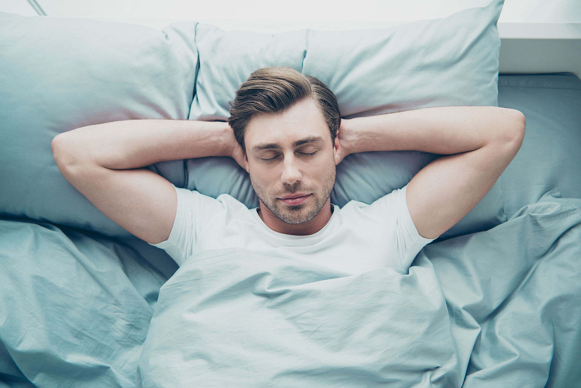 Zentrum für Schlafmedzinin im EvKB Ein Mann liegt im Bett. Von oben fotografiert.