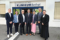 Neuer Direktor für die Neuroradiologie im EvKB: Prof. Dr. Omid Nikoubashman feierlich eingeführt Feierliche Einführung am Evangelischen Klinikum Bethel: Univ.-Prof. Dr. Omid Nikoubashman (Mitte) mit seiner Frau Jenny, wird begrüßt von Pastor Philipp Katzmann, Thorsten Kaatze, Pastor Ulrich Pohl, Petra Krause und Univ.-Prof. Dr. Thomas Vordemvenne (v.r.n.l.).