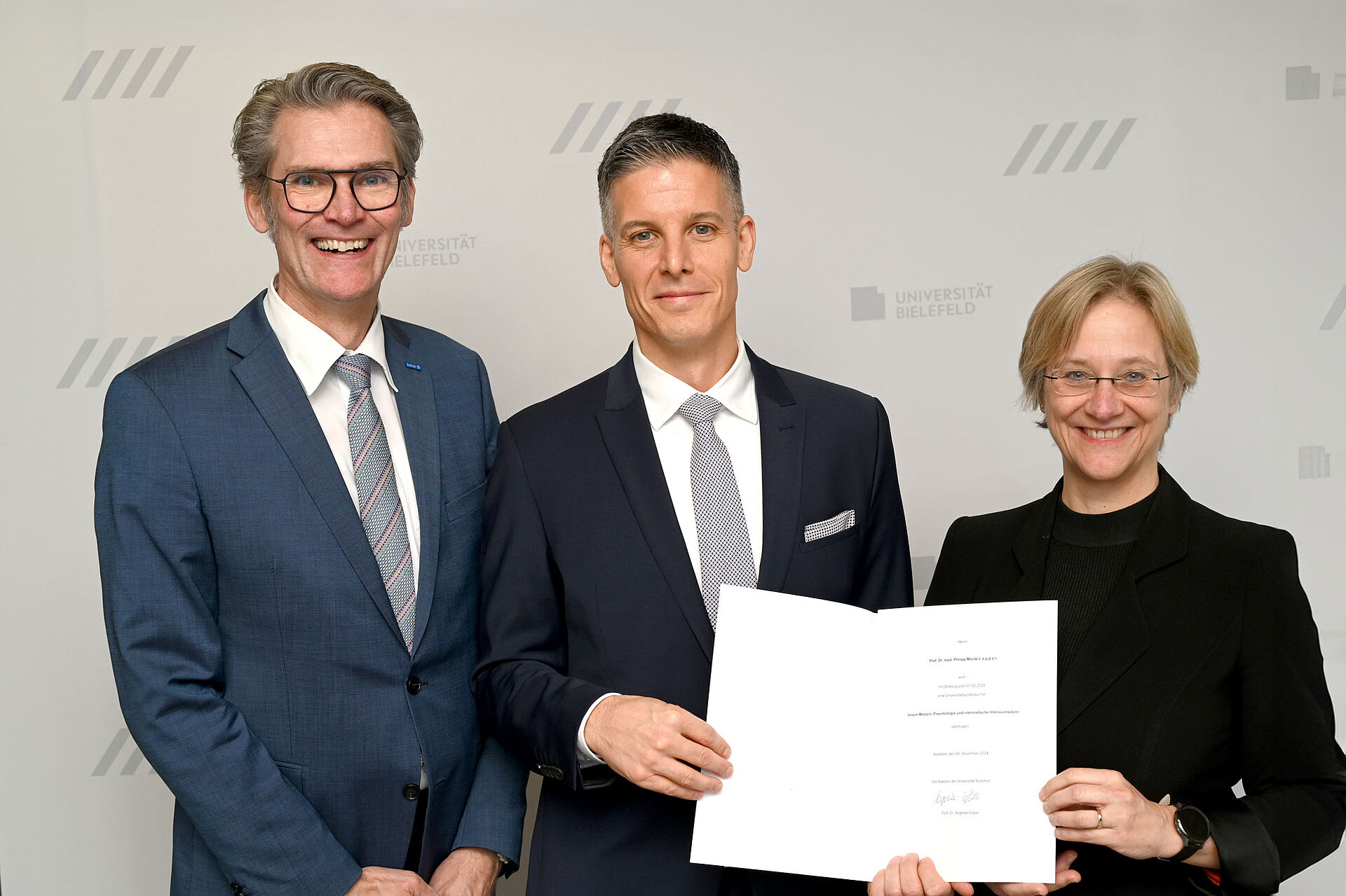 Philipp Lepper zum Universitätsprofessor berufen – Lungenklinik in Bethel wird universitär Philipp Lepper (Mitte) erhält die Berufungsurkunde von der Rektorin der Universität Bielefeld, Prof. Dr. Angelika Epple. Links: EvKB-Geschäftsführer Thorsten Kaatze
