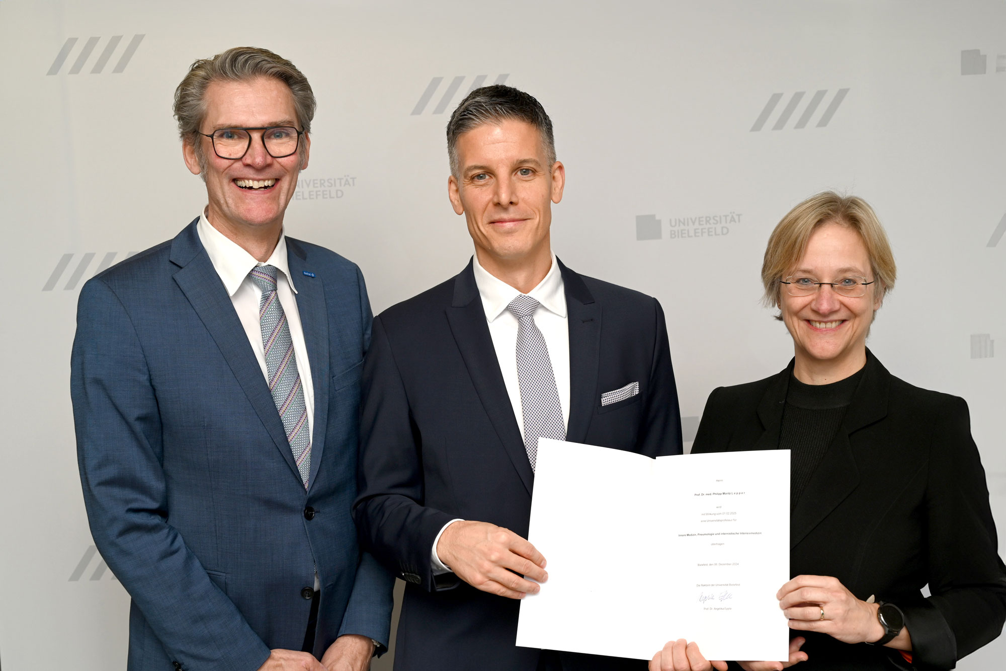 Philipp Lepper zum Universitätsprofessor berufen – Lungenklinik in Bethel wird universitär Philipp Lepper (Mitte) erhält die Berufungsurkunde von der Rektorin der Universität Bielefeld, Prof. Dr. Angelika Epple. Links: EvKB-Geschäftsführer Thorsten Kaatze