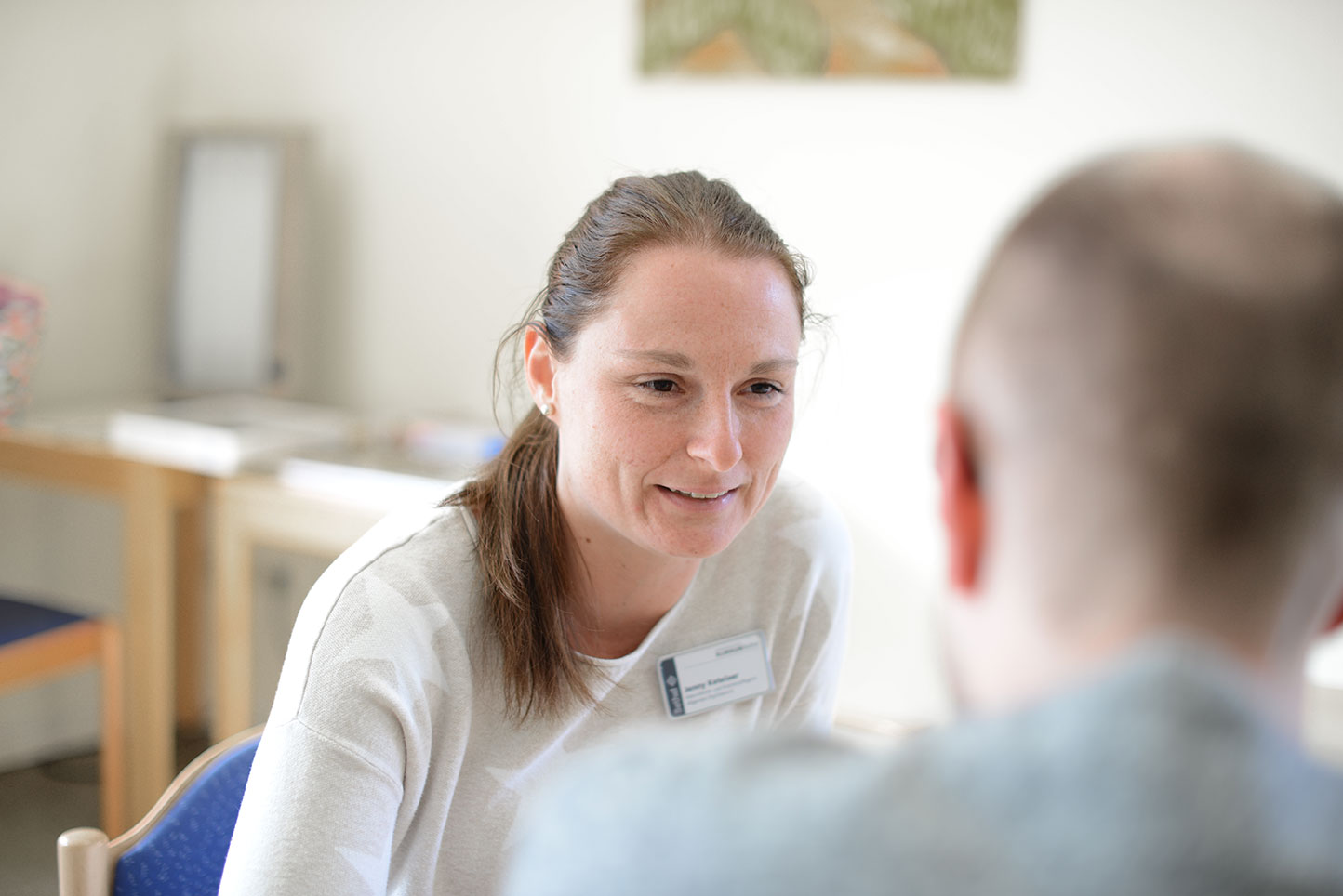 Gerontopsychiatrie im EvKB Eine Mitarbeiterin unterhält sich mit einem Mann.